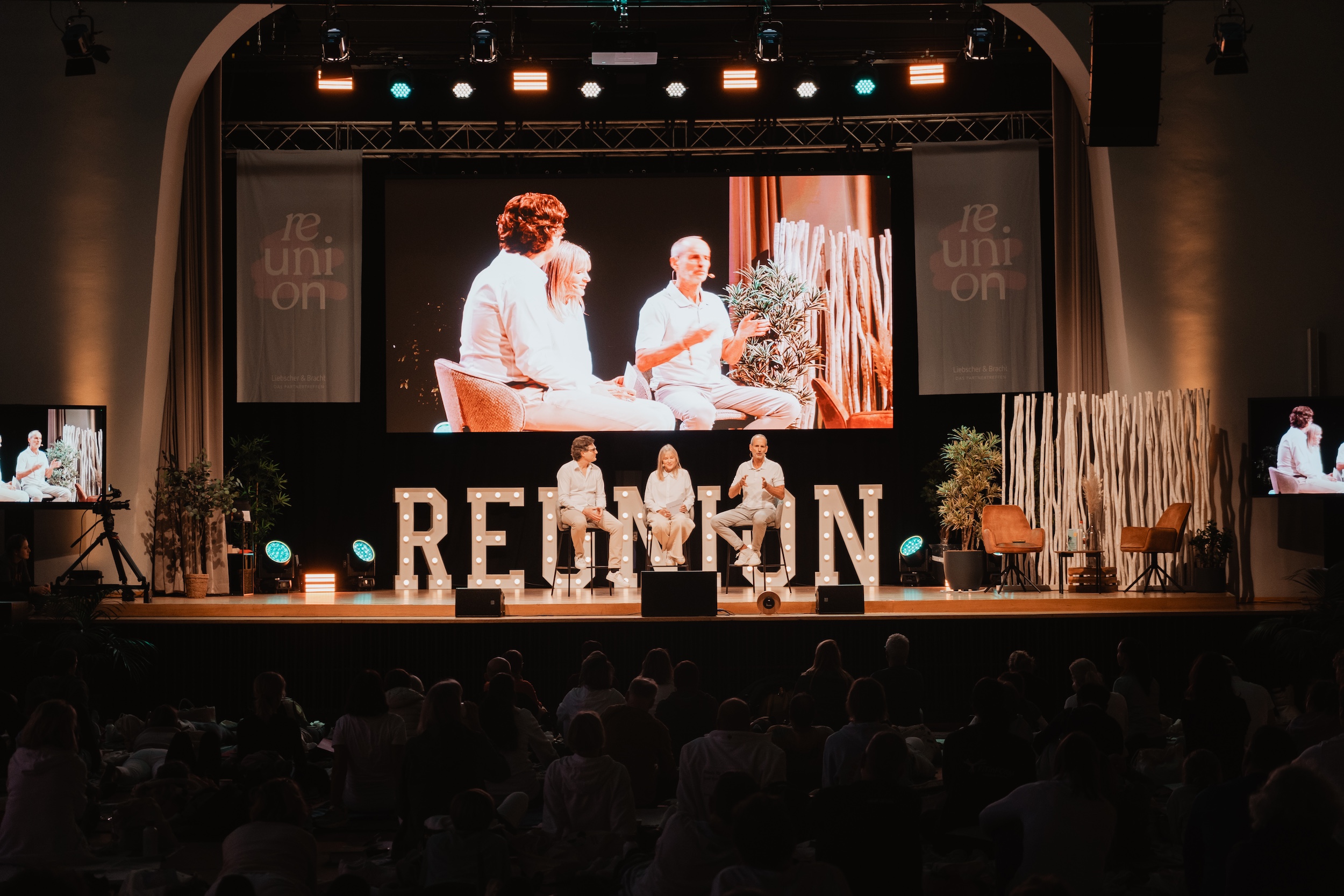 Liebscher & Bracht Community Event — Roland und Petra live auf der Bühne mit 1.200 Menschen im Saal